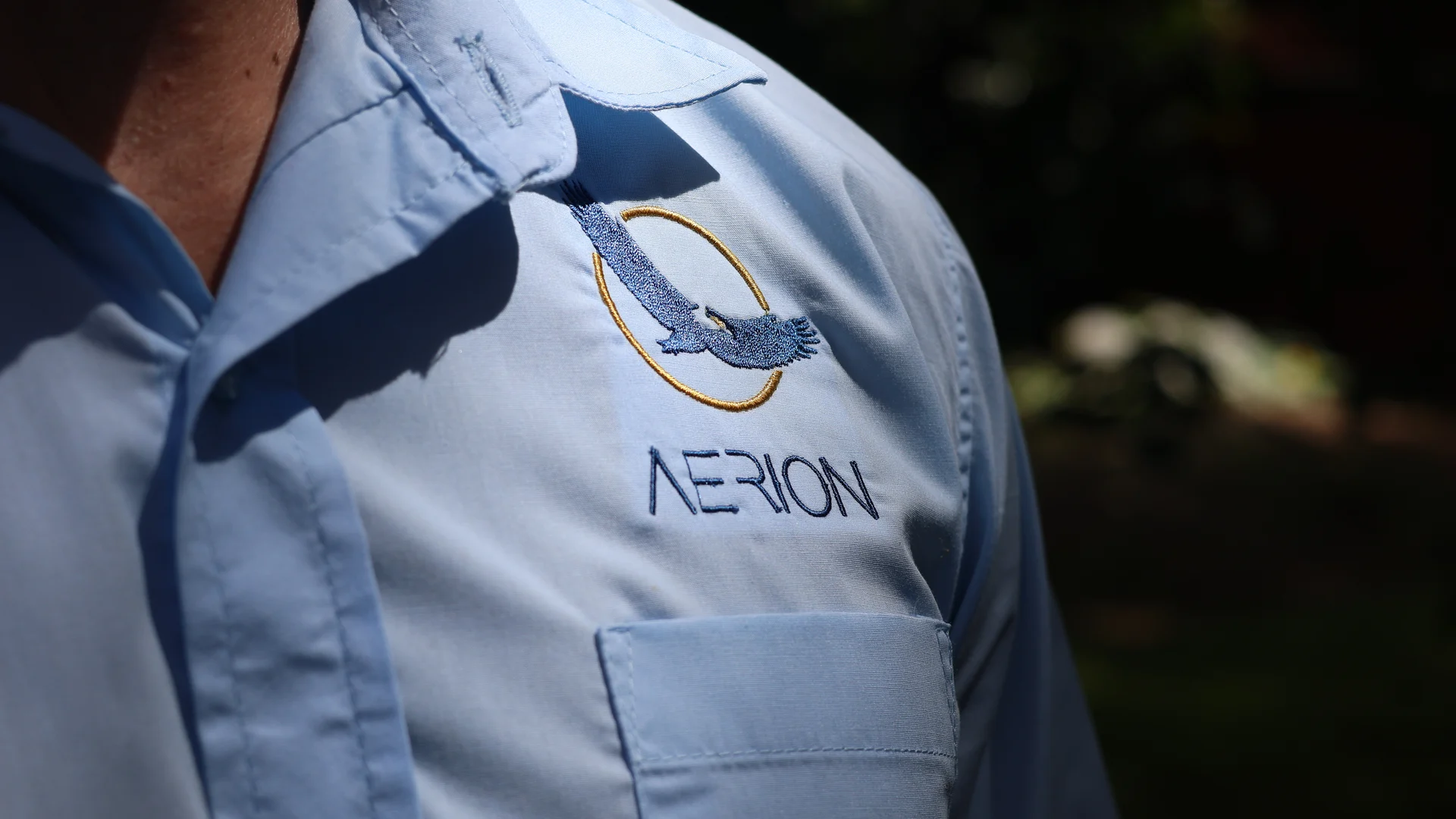 Aerion embroidered logo on a blue work shirt