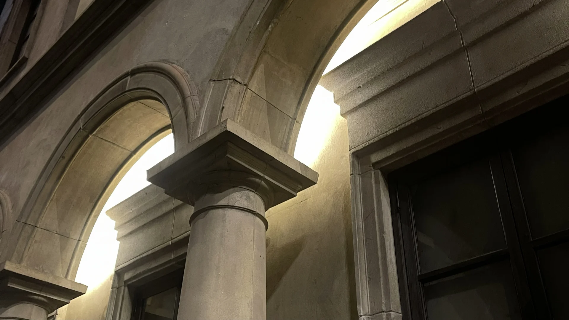 Sunlight falling across stone arches and a column