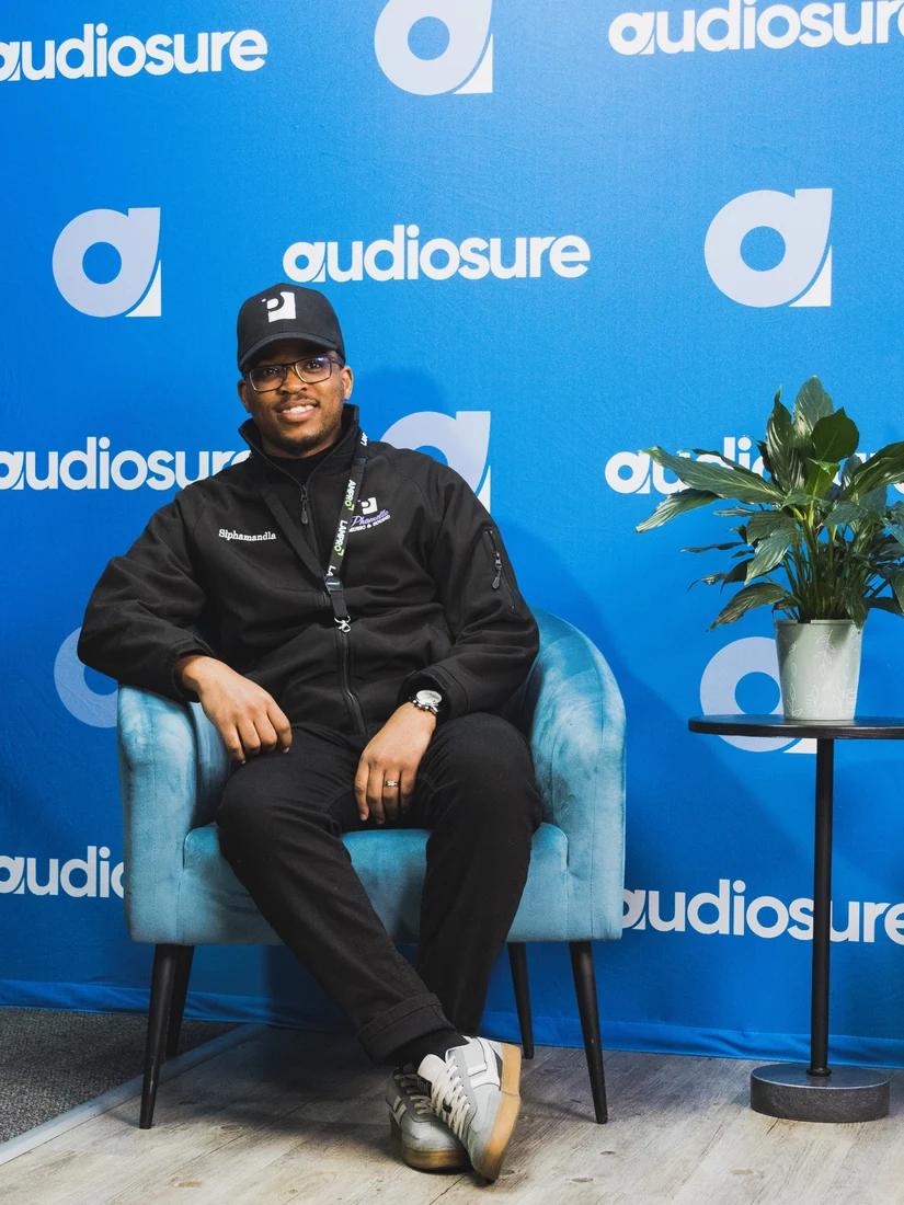 Guest seated at an Audiosure event backdrop