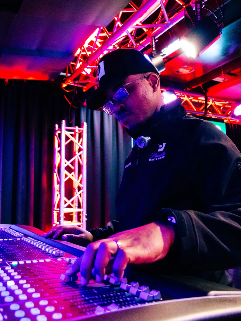 DJ performing under pink and blue stage lights
