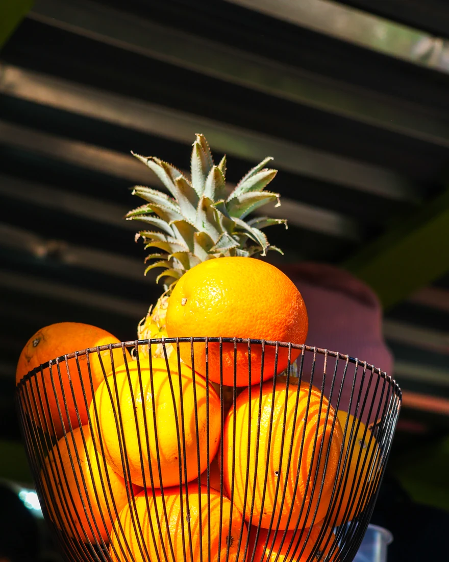 Oranges and pineapple in a wire basket