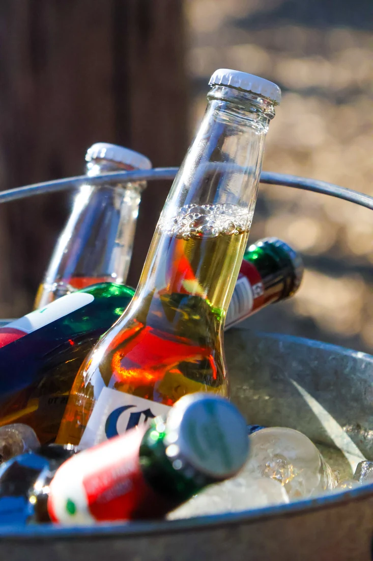 Glass bottles in an ice bucket with peppers