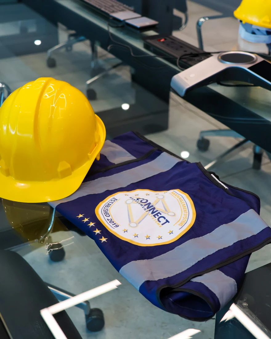 Yellow hard hat beside branded workwear
