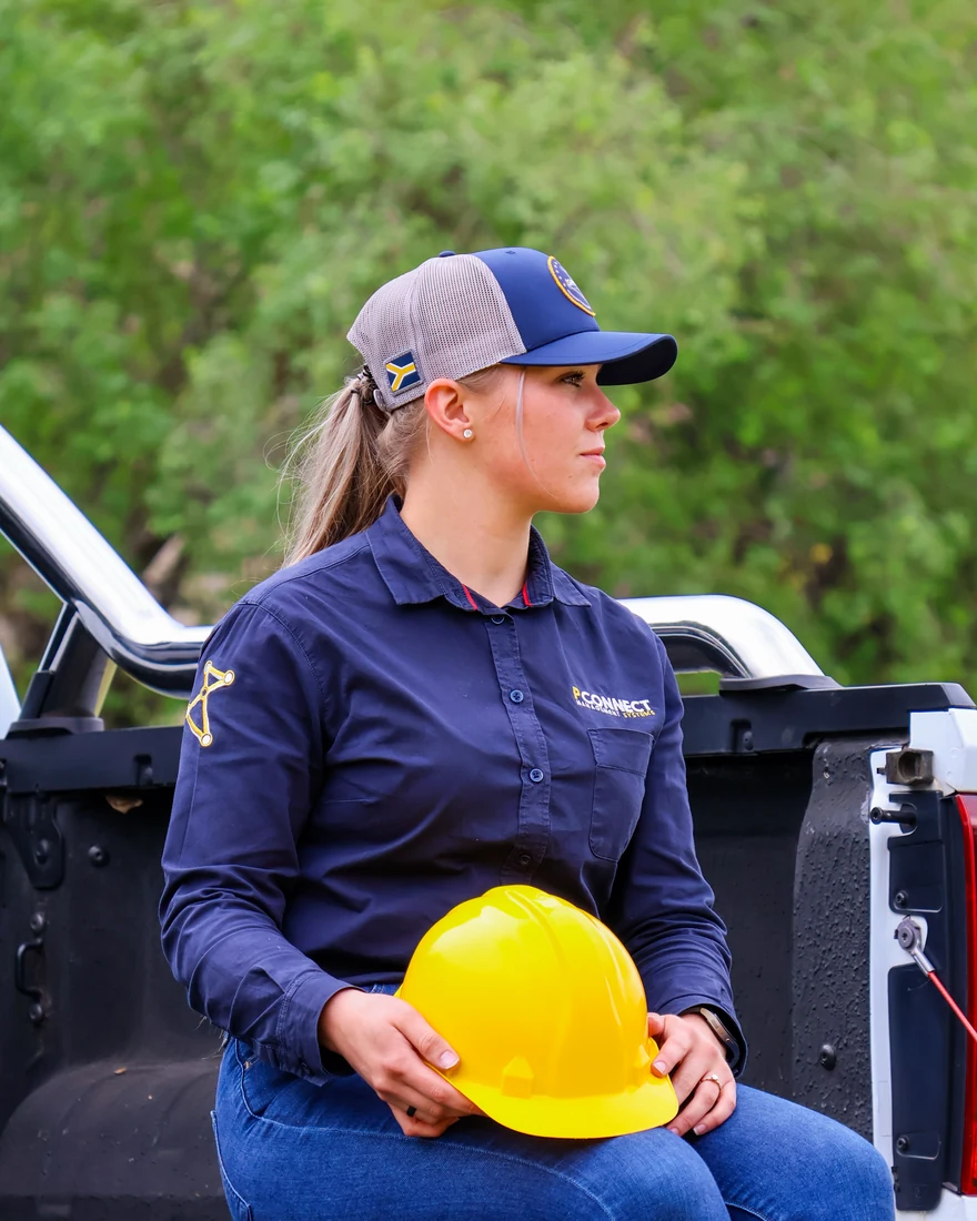 Outdoor portrait in purple workwear holding a yellow hard hat