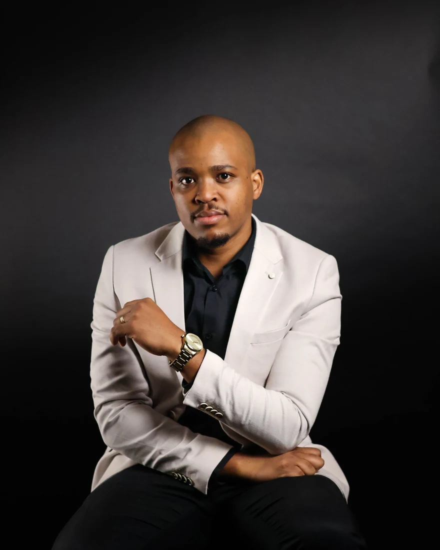 Studio portrait in a beige jacket against black