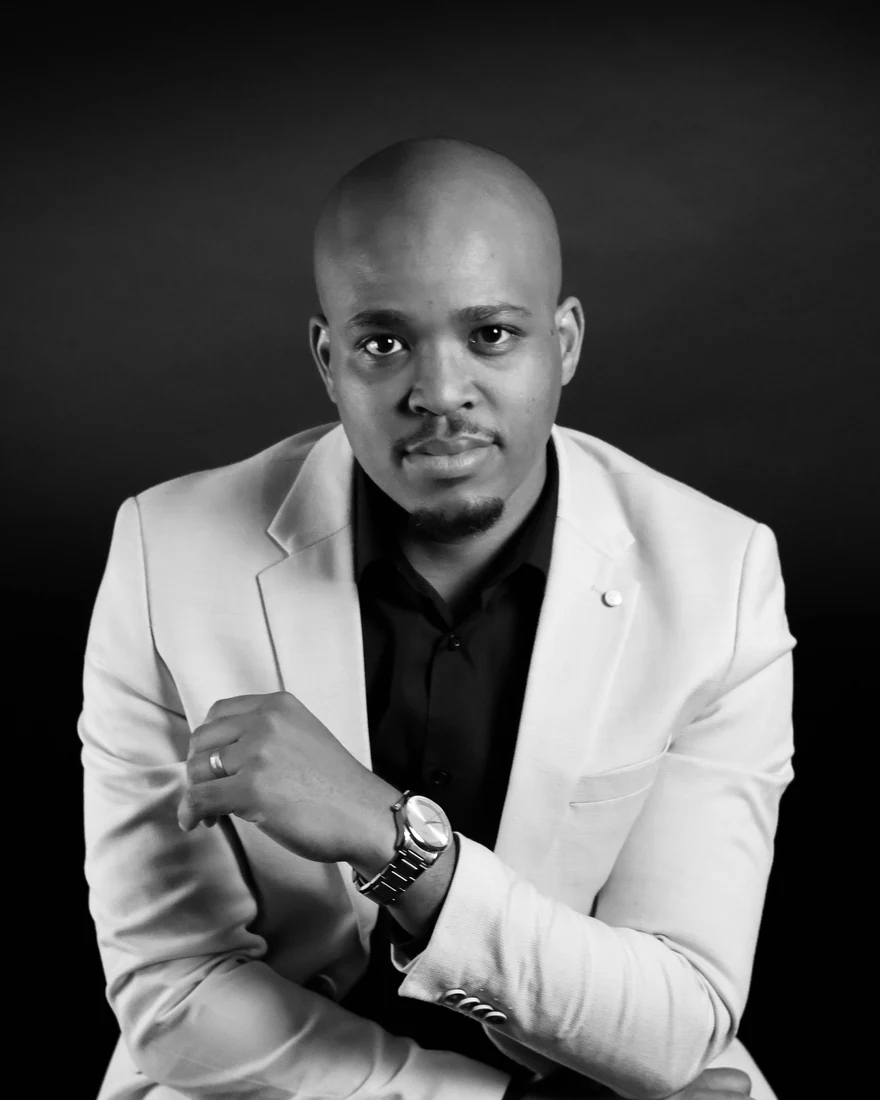 Black and white studio portrait in a beige jacket